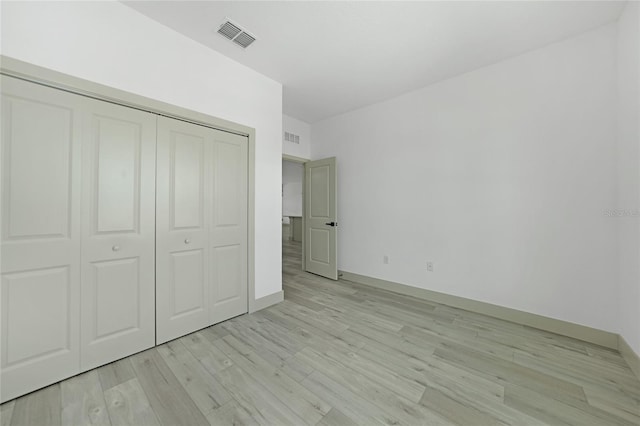 unfurnished bedroom featuring a closet and light hardwood / wood-style floors