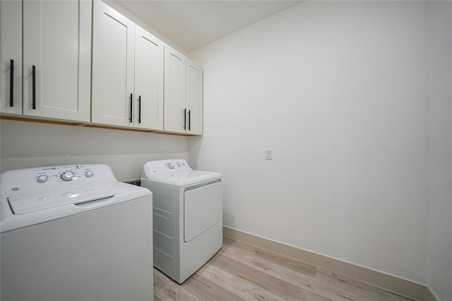 washroom featuring cabinets, independent washer and dryer, and light wood-type flooring