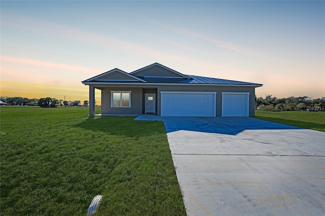 single story home featuring a yard and a garage