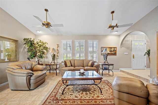 living area featuring light tile patterned floors, baseboards, arched walkways, a ceiling fan, and lofted ceiling