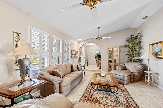 living room featuring light tile patterned floors, visible vents, arched walkways, a ceiling fan, and vaulted ceiling