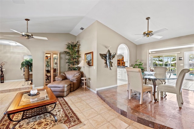 dining space featuring ceiling fan, visible vents, arched walkways, and vaulted ceiling