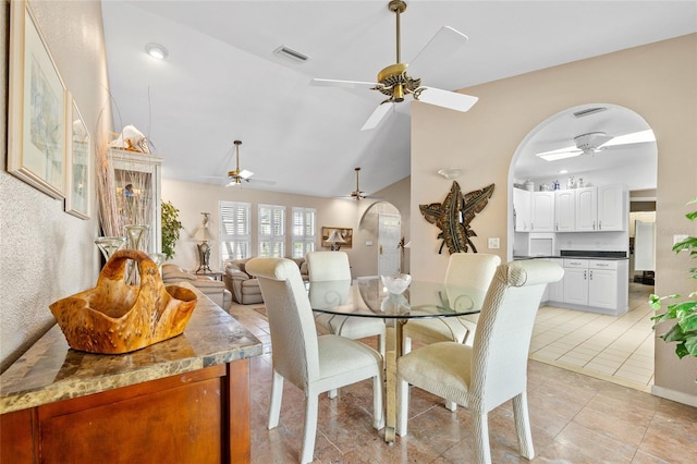 dining space featuring arched walkways, ceiling fan, light tile patterned floors, lofted ceiling, and visible vents