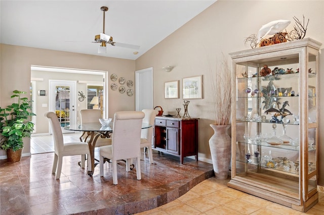 dining room with a ceiling fan, lofted ceiling, and baseboards