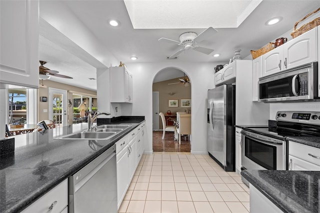 kitchen featuring light tile patterned floors, appliances with stainless steel finishes, white cabinetry, a sink, and ceiling fan