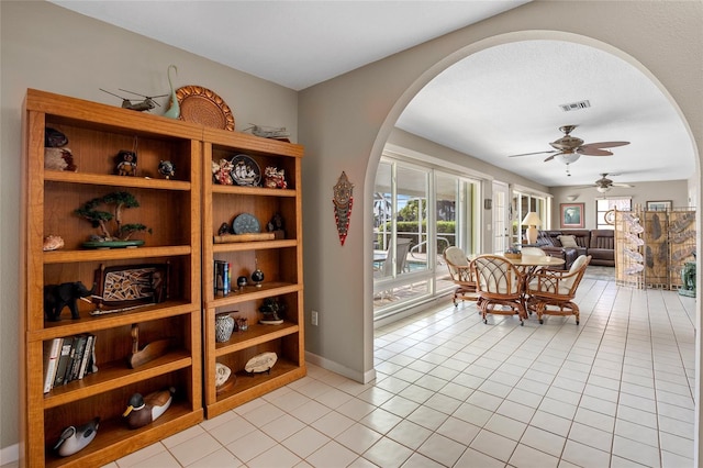 wine cellar featuring light tile patterned floors, arched walkways, visible vents, and a ceiling fan