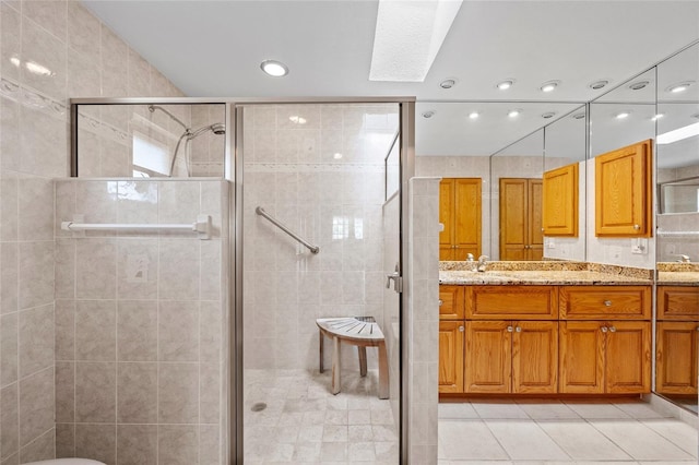 bathroom with double vanity, a stall shower, a sink, and tile patterned floors