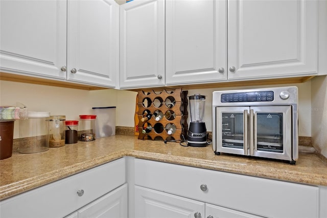 kitchen with a toaster, white cabinetry, and light countertops