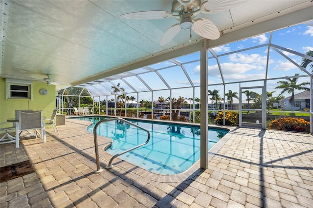 pool featuring a patio area, glass enclosure, and a ceiling fan