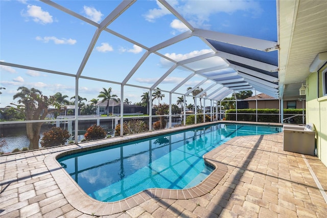 outdoor pool with a patio, a water view, and glass enclosure