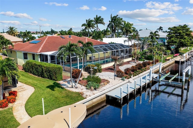 view of dock with a lawn, a water view, boat lift, and a lanai