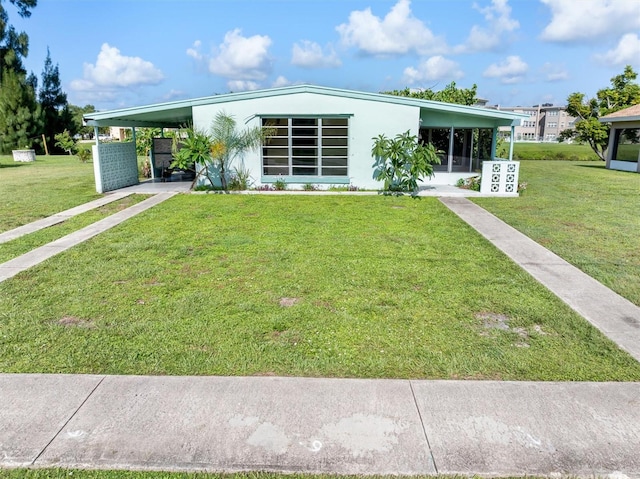 view of front facade featuring a front yard and a carport