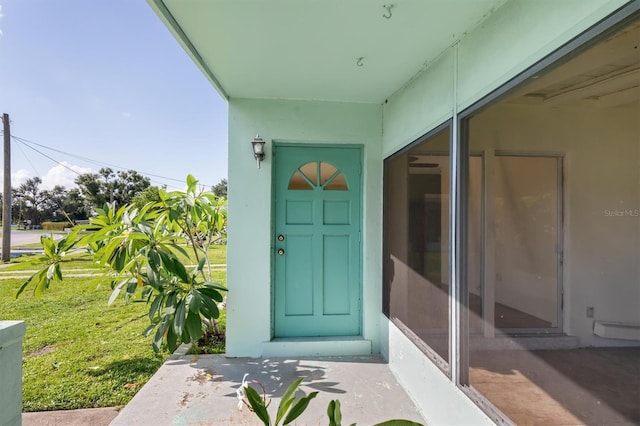 doorway to property featuring a lawn