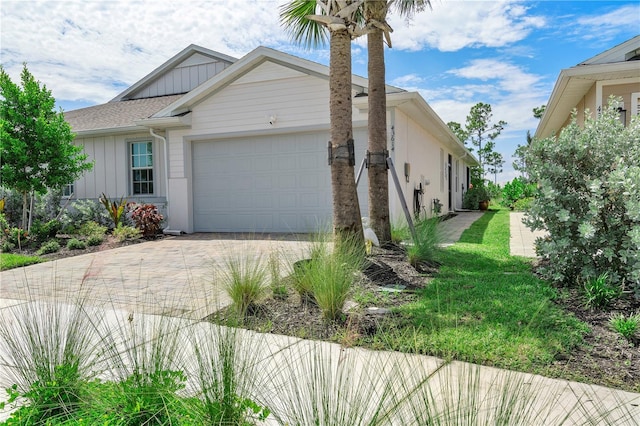 view of property exterior featuring decorative driveway and a garage