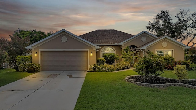 single story home featuring a lawn and a garage