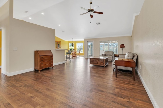 interior space with dark wood-type flooring, ceiling fan, ornamental molding, and vaulted ceiling