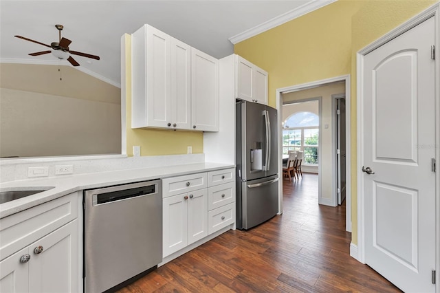 kitchen with lofted ceiling, white cabinetry, ornamental molding, dark hardwood / wood-style flooring, and stainless steel appliances