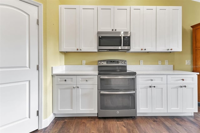 kitchen with white cabinetry, appliances with stainless steel finishes, and dark wood-type flooring