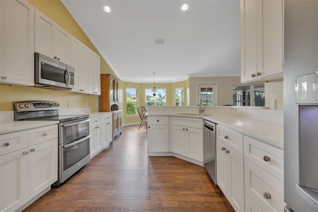 kitchen with stainless steel appliances, sink, white cabinets, and kitchen peninsula