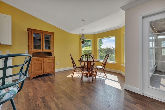 dining room featuring vaulted ceiling, dark wood-type flooring, and crown molding