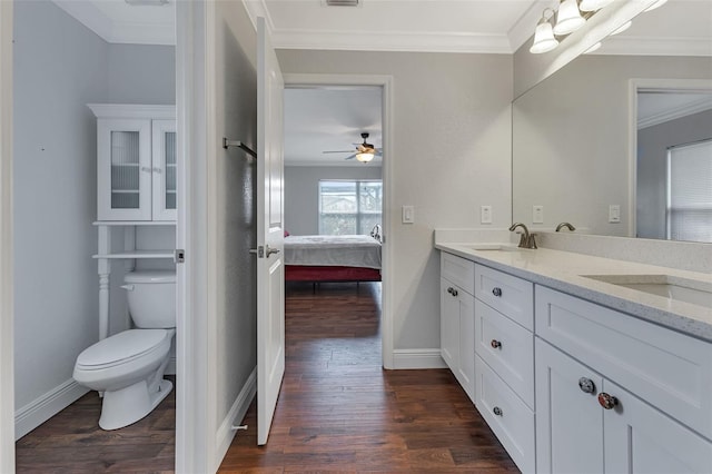 bathroom featuring vanity, crown molding, toilet, and hardwood / wood-style flooring