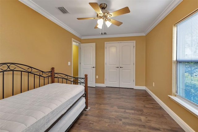 bedroom with dark hardwood / wood-style flooring, ornamental molding, a closet, and ceiling fan