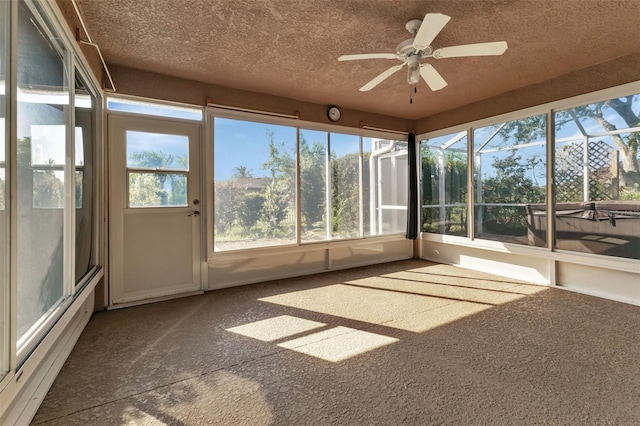 unfurnished sunroom featuring ceiling fan and a wealth of natural light