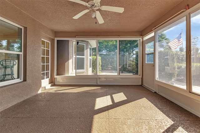 unfurnished sunroom featuring ceiling fan