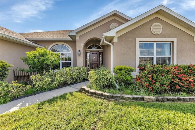 property entrance featuring a lawn