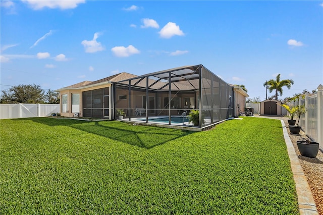 back of house featuring a yard, a storage unit, and a lanai