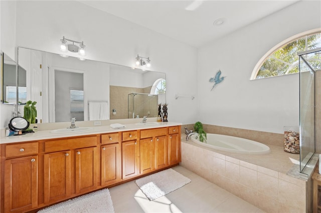 bathroom with tile patterned flooring, separate shower and tub, and dual bowl vanity