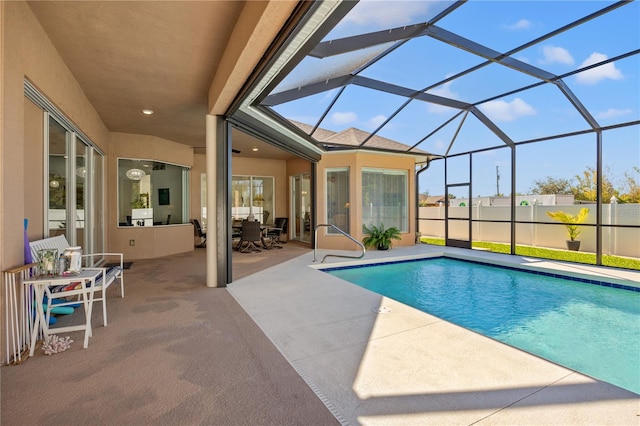 view of pool with glass enclosure and a patio area