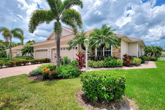 mediterranean / spanish house with a garage and a front lawn