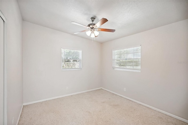 empty room with ceiling fan and a textured ceiling