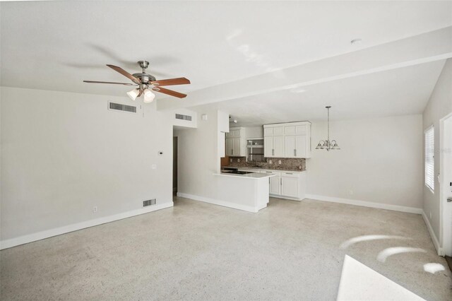 unfurnished living room with ceiling fan with notable chandelier