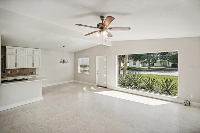 unfurnished living room featuring ceiling fan, lofted ceiling with beams, and a textured ceiling