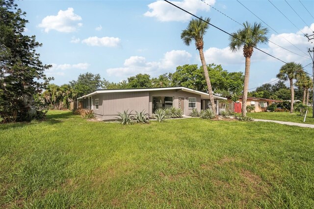 rear view of property featuring a lawn