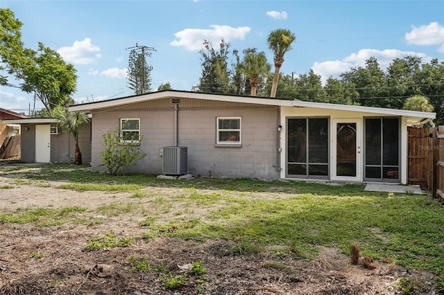 1642 Banyan Dr, Venice, FL 34293 - back of house with a lawn, fence, a sunroom, and central air condition unit