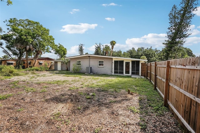 1642 Banyan Dr, Venice, FL 34293 - back of property featuring concrete block siding, a yard, central AC unit, a sunroom, and fence