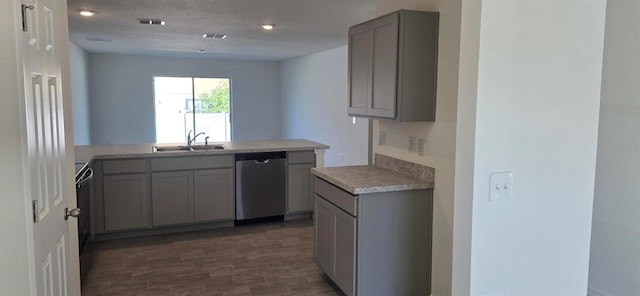 kitchen with dishwasher, a sink, gray cabinets, light countertops, and a peninsula