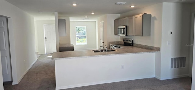 kitchen with kitchen peninsula, appliances with stainless steel finishes, carpet floors, gray cabinets, and sink