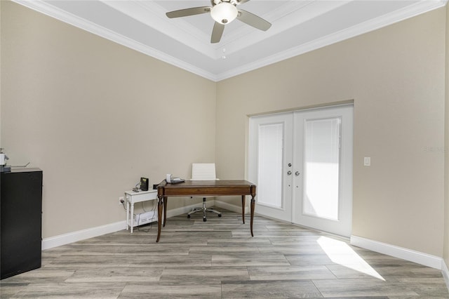 home office featuring ceiling fan, a tray ceiling, crown molding, light wood-type flooring, and french doors