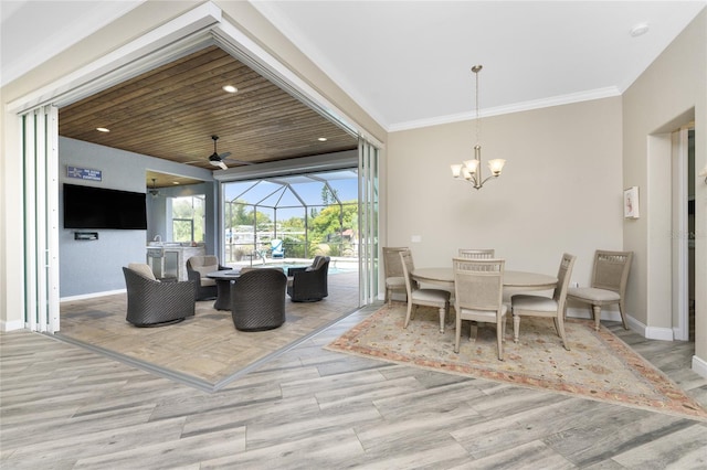 dining room featuring crown molding, light hardwood / wood-style flooring, and ceiling fan with notable chandelier