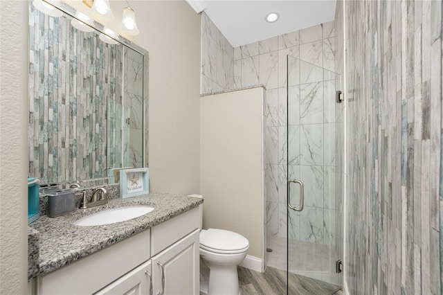 bathroom with vanity, toilet, and a shower with shower door