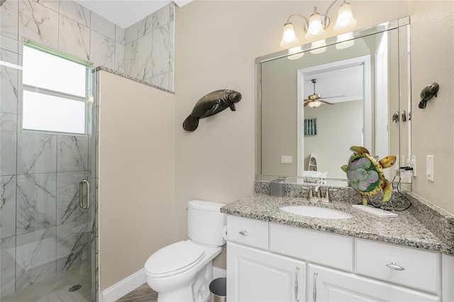 bathroom with vanity, ceiling fan, a shower with shower door, and toilet