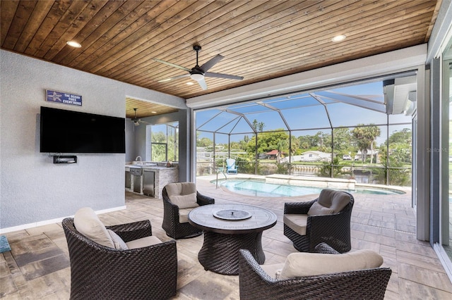 view of patio with ceiling fan, outdoor lounge area, glass enclosure, and a wet bar