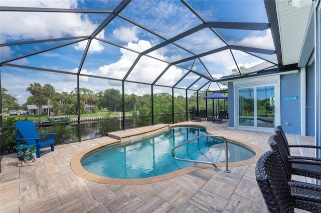 view of pool with a water view, a patio area, and glass enclosure