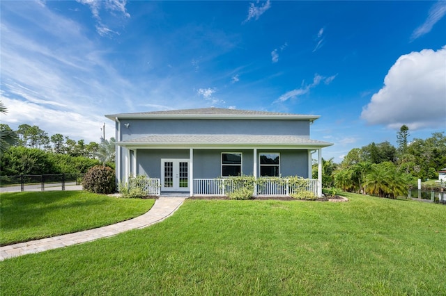 rear view of house featuring french doors and a lawn