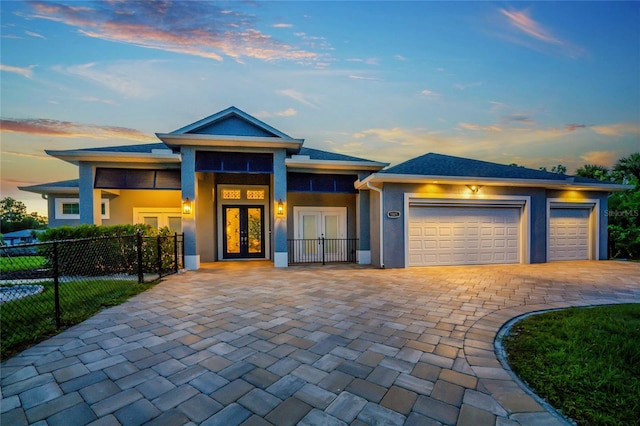 prairie-style home featuring a garage and french doors