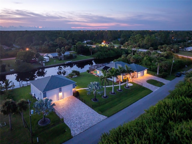 aerial view at dusk featuring a water view